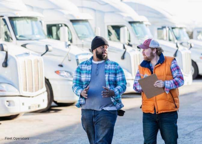 Two fleet operators walking among trucks